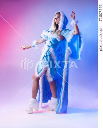 a woman in a blue snow maiden costume poses on a light neon background a woman in a blue snow maiden costume poses on a light neon background 71807363