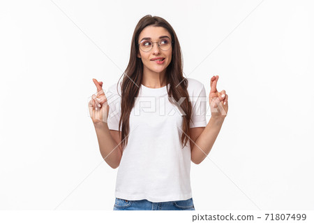 Waist-up portrait of hopeful pretty brunette female anticipating miracle, biting lip tempting, want dream come true, look away thoughtful, cross fingers good luck, making wish, white background 71807499
