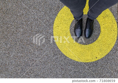 Black shoes standing in yellow circle on the asphalt concrete floor. Comfort zone or frame concept. Feet standing inside comfort zone circle. Place for text, banner Black shoes standing in yellow circle on the asphalt concrete floor. Comfort zone or frame concept. Feet standing inside comfort zone circle. Place for text, banner 71808659