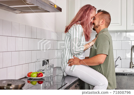 side view on romantic couple hugging in the kitchen side view on romantic couple hugging in the kitchen 71808796