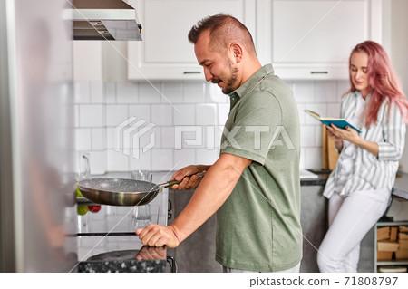 man cooking in the morning, couple enjoying spending time together man cooking in the morning, couple enjoying spending time together 71808797