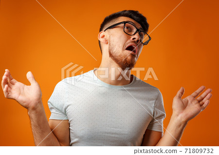 Portrait of young nerd man shrugging shoulders, I don't know gesture Portrait of young nerd man shrugging shoulders, I don't know gesture 71809732