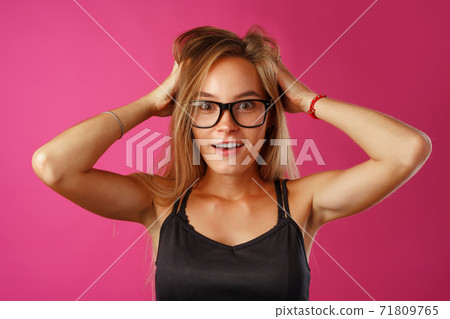 Shocked and amazed young blonde woman close up portrait. 71809765