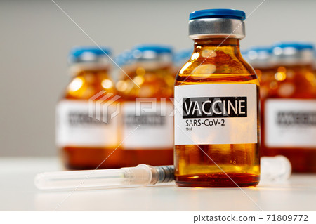 Sars-cov-2 vaccine vial bottles on white table 71809772