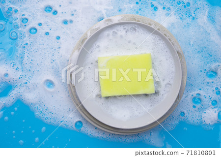 Washing dishes on wet blue background with soapy foam. Washing dishes on wet blue background with soapy foam. 71810801