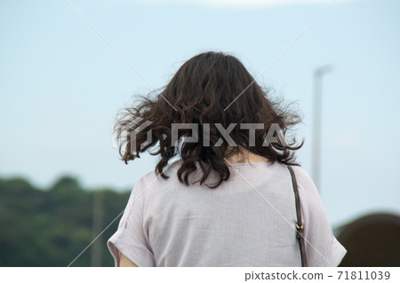 Long-haired woman back view 71811039