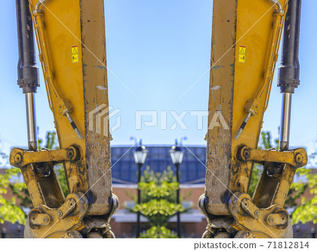 Dual views of a yellow tractor arm vertical Dual views of a yellow tractor arm vertical 71812814