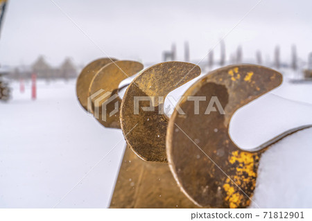 Teeth of an excavator bucket against a snowy landscape in Daybreak Utah Teeth of an excavator bucket against a snowy landscape in Daybreak Utah 71812901