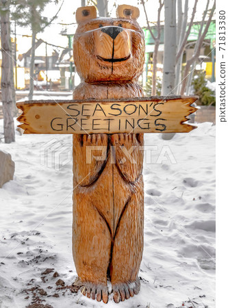 Bear wood sculpture on a landscape covered with powdery white snow in winter 71813380