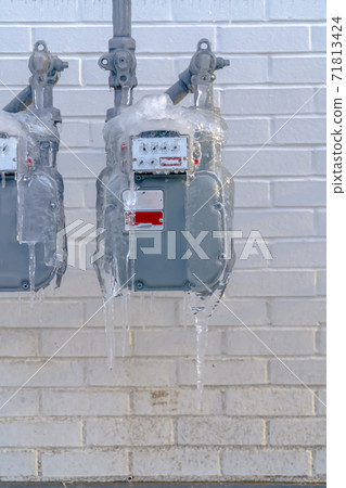 Close up view of a water meter outside a building with white brick wall Close up view of a water meter outside a building with white brick wall 71813424