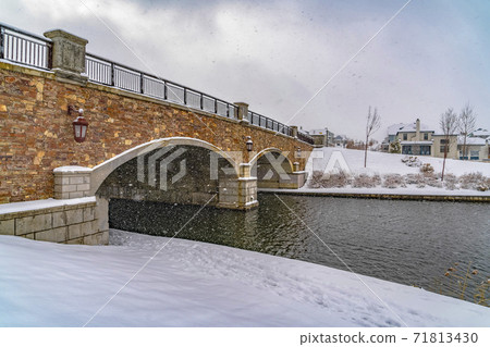 Snowy landscape of a lake with bridge against cloudy sky in Daybreak Utah 71813430