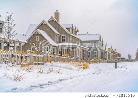 Trail impressed on snow covered ground along houses during winter season Trail impressed on snow covered ground along houses during winter season 71813510