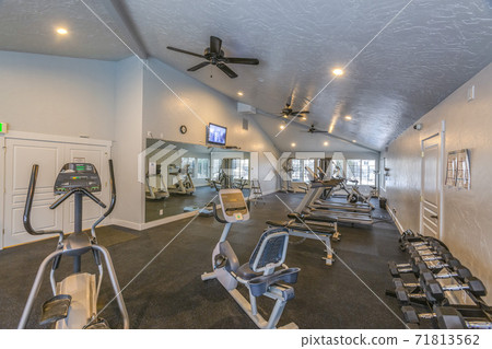 Interior of a spacious fitness gym with various exercise equipment 71813562