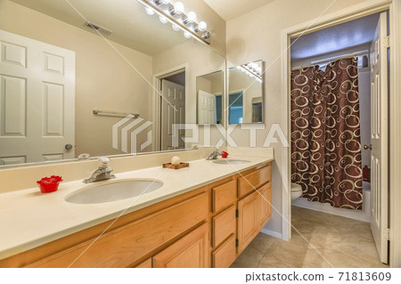 Vanity with double sink and wood cabinets inside the small bathroom of a home Vanity with double sink and wood cabinets inside the small bathroom of a home 71813609