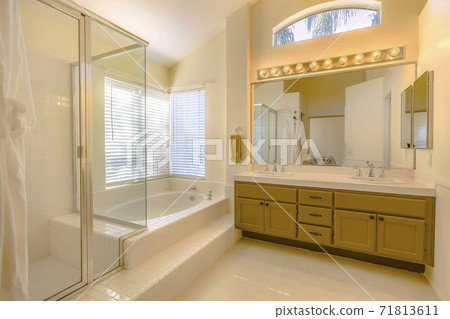 Built in bathtub and shower with glass door inside a beautiful bathroom 71813611