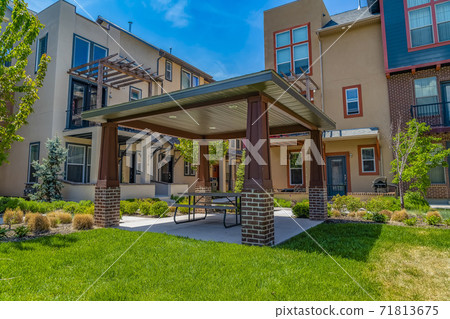 Patio with table and seats under the a roof supported by four pillars 71813675