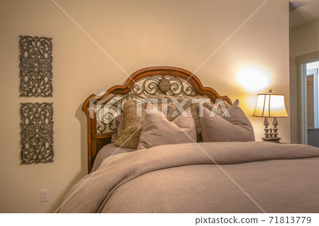 Bed with wood and wrought iron headboard inside the bedroom of a home 71813779