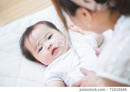 A woman who puts her baby on a futon A woman who puts her baby on a futon 71818886
