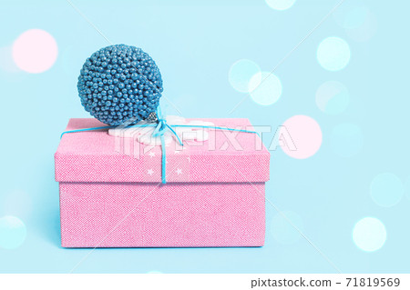 Red Christmas gift box with blue bauble on blue Red Christmas gift box with blue bauble on blue 71819569
