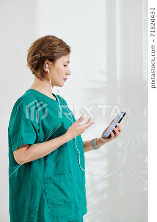 Surgeon calling coworker Surgeon calling coworker 71820431