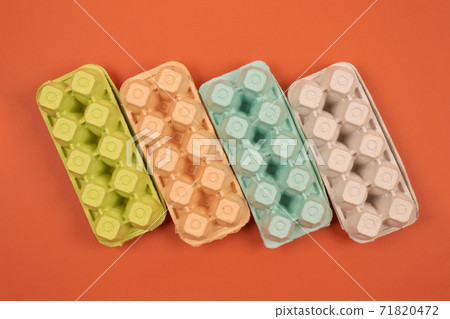 Multicolored organic egg trays on orange background with copyspace for your text. Biodegradable and compostable paper packaging. Waste sorting at home concept. Selective focus Multicolored organic egg trays on orange background with copyspace for your text. Biodegradable and compostable paper packaging. Waste sorting at home concept. Selective focus 71820472