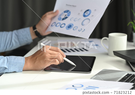 A business man developing a business project and analyzing market data information on a modern digital tablet computer. A business man developing a business project and analyzing market data information on a modern digital tablet computer. 71823212