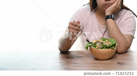 Cropped shot of an unhappy overweight woman bored of diets eating healthy food. 71823252