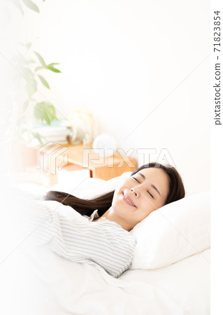 Young woman waking up in the bedroom 71823854