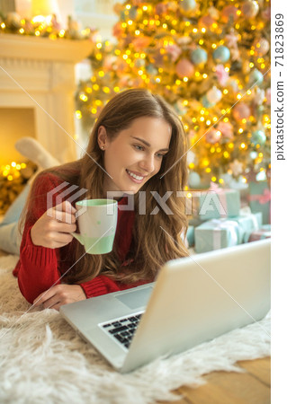 Pretty young woman having an online date and feeling pleased Pretty young woman having an online date and feeling pleased 71823869
