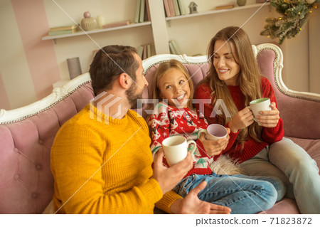 Cute family sitting on the sofa and feeling good Cute family sitting on the sofa and feeling good 71823872