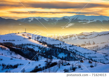 winter landscape in mountains at sunrise. beautiful rural area of carpathian mountains with snow covered hills. glowing clouds on the sky. frosty weather 71824013