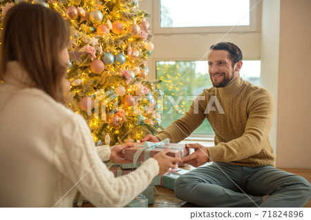 Handsome bearded man giving a present to his girlfriend Handsome bearded man giving a present to his girlfriend 71824896