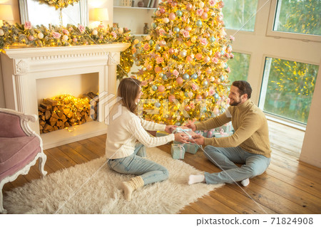 Handsome bearded man giving a present to his girlfriend Handsome bearded man giving a present to his girlfriend 71824908