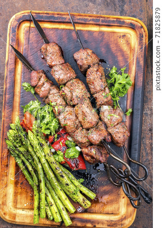 Traditional Russian shashlik on a barbecue skewer with green asparagus and paprika  71825879