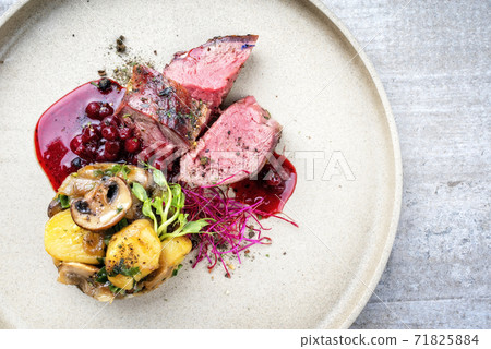 Modern style barbecue dry aged sliced venison fillet steak with potato mushroom terrine  71825884