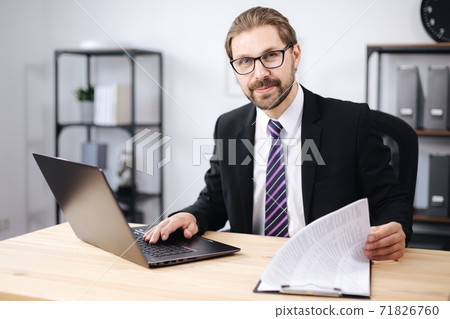 Happy man using laptop at office Happy man using laptop at office 71826760
