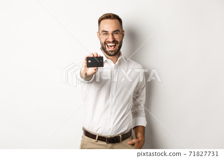 Excited caucasian man in glasses showing credit card, concept of shopping Excited caucasian man in glasses showing credit card, concept of shopping 71827731