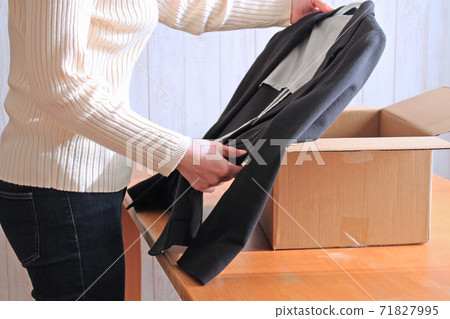 一個女人在她的行李前攤開夾克 71827995