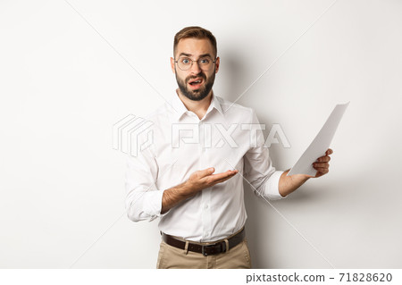 Disappointed boss scolding for bad report, pointing at documents and looking confused, standing over white background Disappointed boss scolding for bad report, pointing at documents and looking confused, standing over white background 71828620