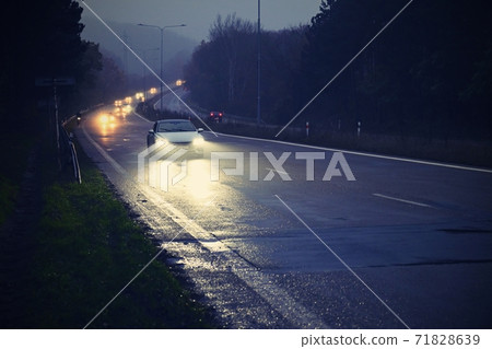 Bad weather driving - foggy hazy country road. Motorway - road traffic. Winter - autumn time. 71828639