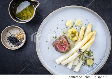 dry aged sliced fillet steak with white asparagus and roast potatoes dry aged sliced fillet steak with white asparagus and roast potatoes 71829058