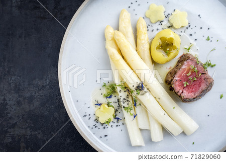 dry aged sliced fillet steak with white asparagus and roast potatoes 71829060