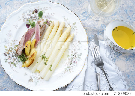 Traditional sliced pork fillet steak with white asparagus in butter sauce and roast potatoes 71829082