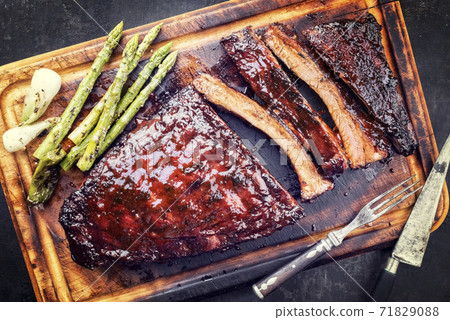 Barbecue spare ribs St Louis cut with hot honey chili marinade and green asparagus offered 71829088