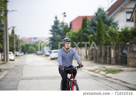 Portrait of down syndrome adult man with bicycle cycling outdoors on street. 71832016