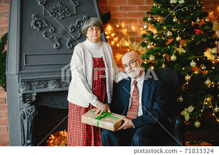 An elegant old couple are celebrating Christmas An elegant old couple are celebrating Christmas 71833324