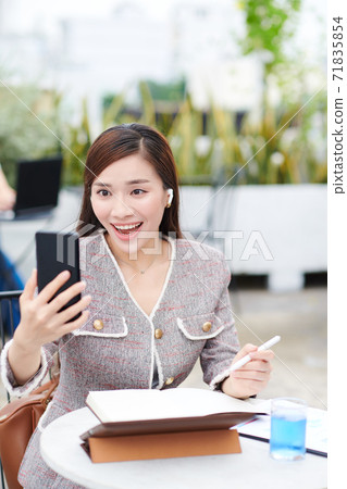 Businesswoman video calling her colleague Businesswoman video calling her colleague 71835854