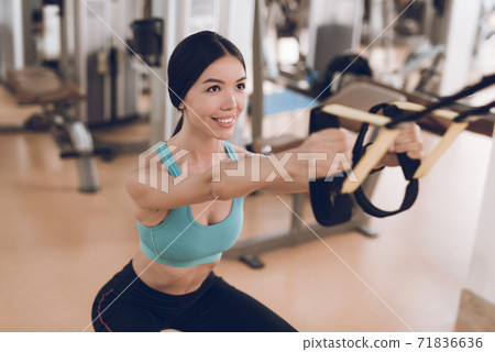 The lady does exercises on uneven bars. 71836636