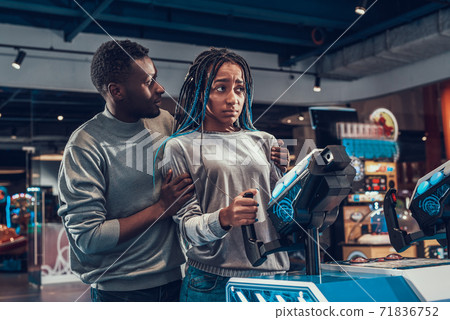 A man hugs a girl who is sad in an center. 71836752
