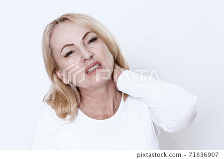 Girl stands on a white background and feels pain. Girl stands on a white background and feels pain. 71836907